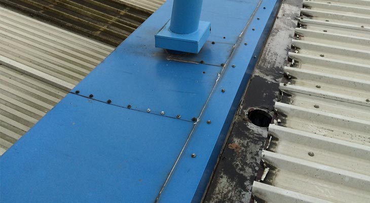 Failing joints to the flashings on the blue perimeter capping.