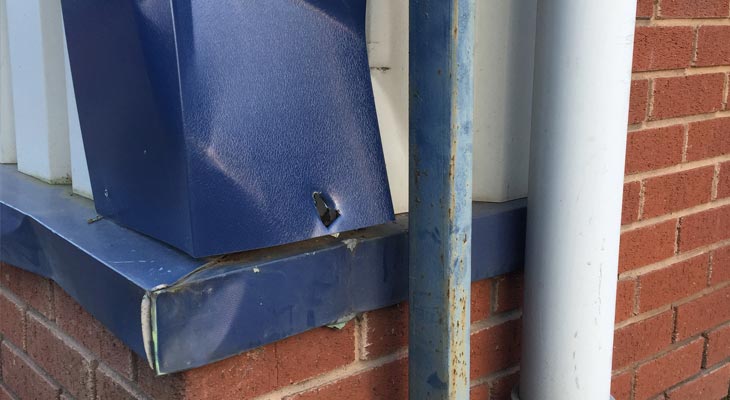 Close up of damaged corner flashing and base sill