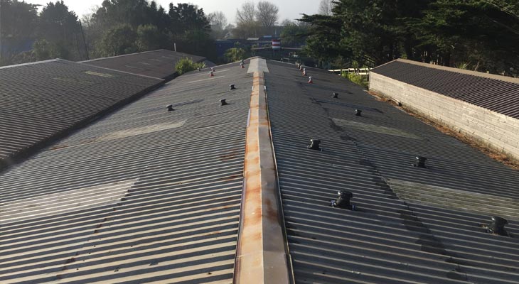 Industrial roof in Weymouth with historic repairs and roof penetrations