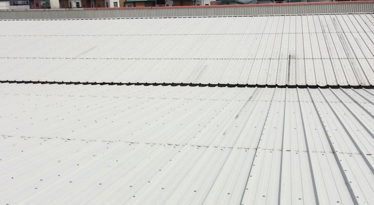 View down industrial roof slope to valley gutter