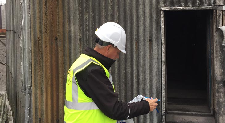 Coverclad manager inspecting non-notifiable asbestos wall cladding