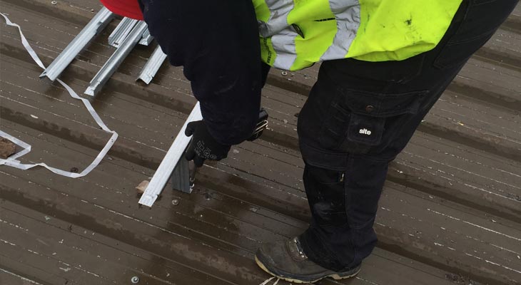 Coverclad industrial roof installer fixing down metal grid system