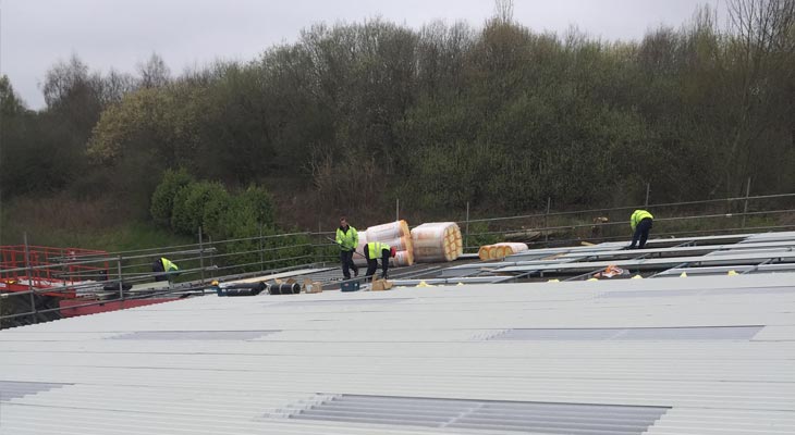 Coverclad industrial roofing installers fixing down metal roof sheets