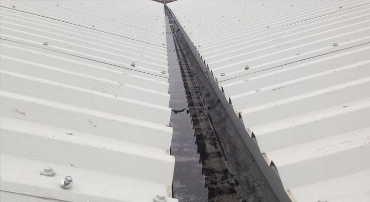 Eaves level view of asbestos roofing overclad