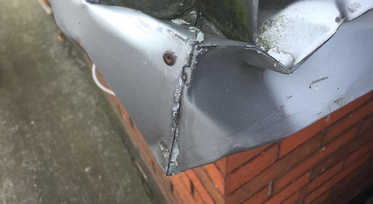 Close-up of vehicle impact damage to wall cladding base flashing