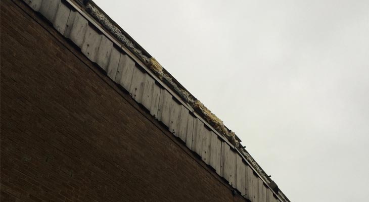 Exposed industrial roofing insulation from missing gable end