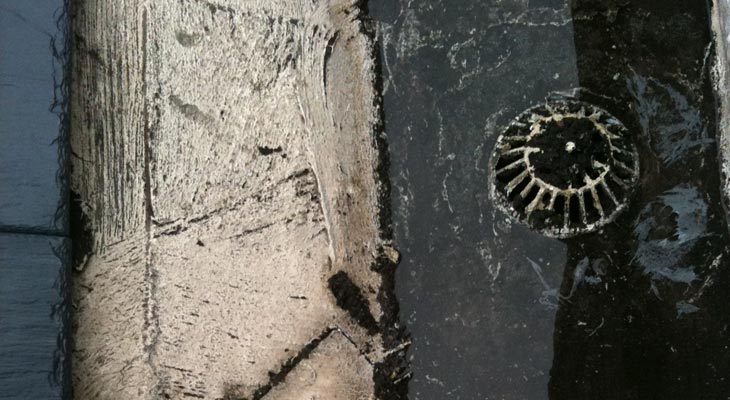 Close-up of cracked and blocked gutter outlet guard