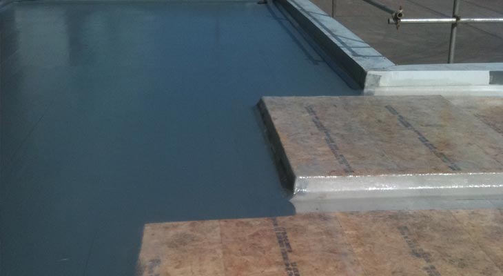 Glass reinforced plastic being applied in sections across flat roof