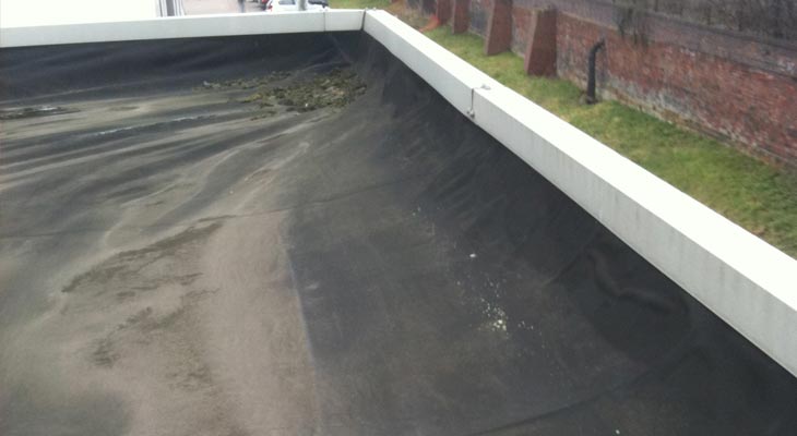 Rubber flat roof after cleaning showing signs of delamination