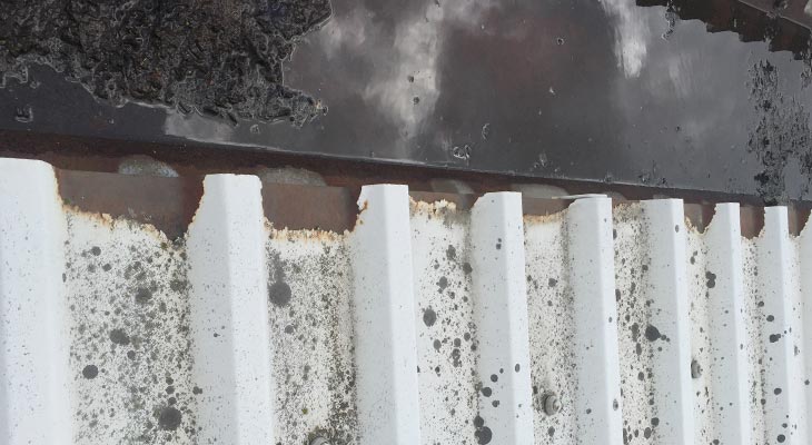 Close-up showing extensive cut edge corrosion to roof sheet eaves