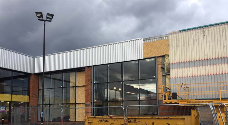 Installing wall cladding above glazing sections