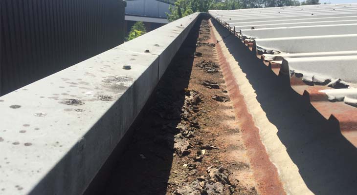 Debris and loose plastisol in rusty gutter