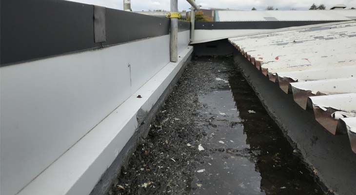 Perimeter gutter stop end with water and debris build-up