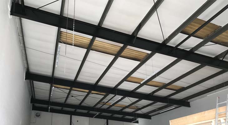 Internal view of old degraded roof lights impeding sunlight into warehouse