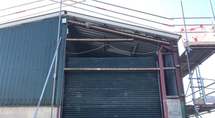 Gable end cladding stripped for roller shutter door height adjustment