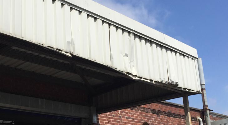 Canopy area with impact damage to the front elevation cladding sheets.