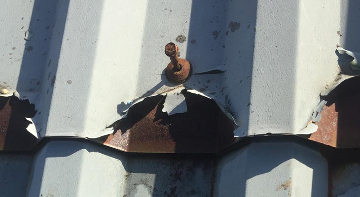 Heavily corroded loose roof fixing with cut edge corrosion