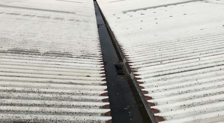 Valley gutter full of water and in need of prepping